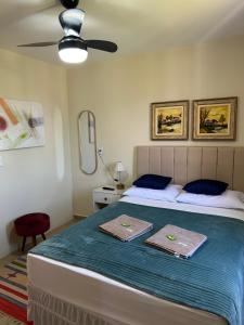 a bedroom with a bed with two towels on it at Chalé 2 vista para montanha in Penedo