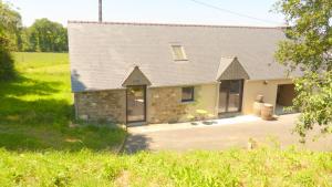 a stone house with a driveway in front of it at La ferme de la Cavalerie in Saint-Gonnery