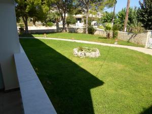 a shadow of a building on a lawn at Hotel Villa Basil in Tsilivi