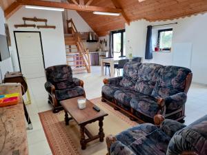 a living room with a couch and two chairs and a table at La ferme de la Cavalerie in Saint-Gonnery