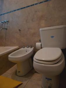 a bathroom with a toilet and a sink at Bernal Alquileres in Viedma