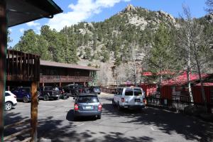 a parking lot with cars parked in front of a mountain at Nicky's Resort in Estes Park