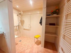 a bathroom with a shower and a yellow stool at Villa del Sol in Büsum +34 photos