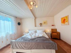 a bedroom with a bed and a chair and a window at Villa del Sol in Büsum
