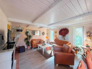 a living room with orange furniture and a white ceiling at Villa del Sol in Büsum