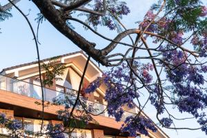 a tree with purple flowers in front of a building at Zenora Hillside Garden in Da Lat