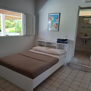 a bedroom with a bed with a sink and a window at La Maison Rose in Le Robert