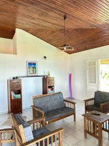 a living room with couches and a wooden ceiling at La Maison Rose in Le Robert