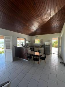 a large kitchen with a table and chairs in it at La Maison Rose in Le Robert +18 photos