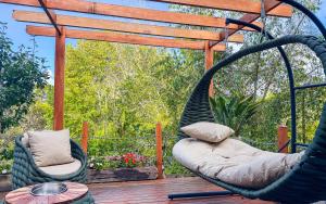 a porch with a hammock and a chair on a deck at Pousada Bella Giornata in Campos do Jordão