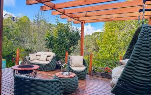 a wooden deck with chairs and a pergola at Pousada Bella Giornata in Campos do Jordão +127 photos