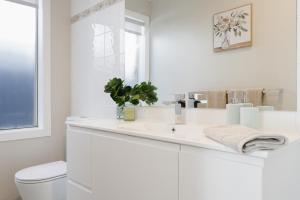 a white bathroom with a sink and a toilet at Ohana Coastal Escape in Rosebud +18 photos