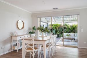 a white dining room with a table and chairs at Ohana Coastal Escape in Rosebud