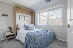 a bedroom with a bed and a window at Ohana Coastal Escape in Rosebud