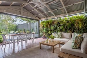 an outdoor living room with a couch and a table at Ohana Coastal Escape in Rosebud