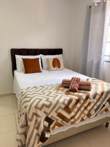 a bed with pillows and a blanket on it at Doce Lar Alto Caparaó in Caparaó Velho