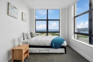 a bedroom with a bed and a large window at U Suites at The Links in Paraparaumu
