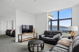 a living room with a couch and a tv at U Suites at The Links in Paraparaumu