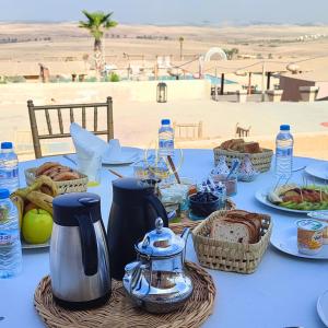 a blue table with baskets of bread and bottles of water at Kal Tenere Luxury Camp in El Karia