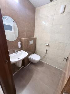 a bathroom with a sink and a toilet and a mirror at Skypod13 in Chandīgarh +6 photos