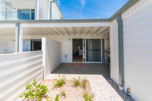 a pivot door to a house with a patio at Harrington Marina in Harrington