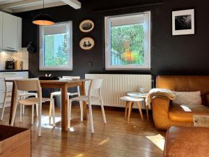 a living room with a table and chairs and a kitchen at Cozy Durbuy Chalet with fireplace in Dochamps