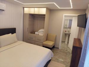 a bedroom with a bed and a chair and a sink at Caye Caulker Condos in Caye Caulker