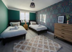 a bedroom with two beds and a dresser and a rug at Private 2 Bed Escape with Huge Parking in Ely