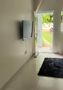 a room with a door with a television and a rug at Apto Cozi in Sorriso