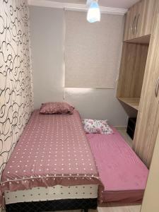 a small bedroom with two beds in it at Apartamento prox Praça Nova Shopping in Araçatuba