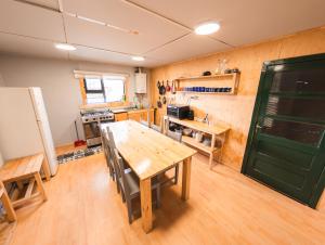 a kitchen with a wooden table and a green door at Patagonia Sweet House in Puerto Natales