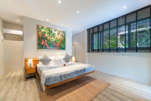 a bedroom with a bed and a large window at Kajali Siargao in General Luna