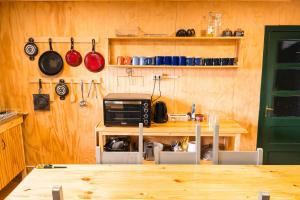 a kitchen with a table and a wooden wall at Patagonia Sweet House in Puerto Natales