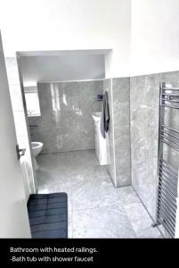 a bathroom with treated wallsbah tub with shower toilet at Medway Hidden Gem in Gillingham