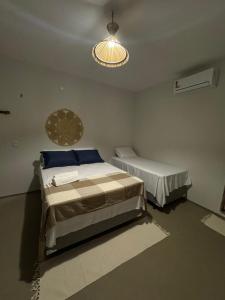 a bedroom with two beds and a chandelier at Pousada Raízzes in Amontada