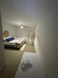 a white room with a bed and a mirror at Pousada Raízzes in Amontada