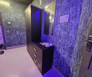 a purple bathroom with a sink and a mirror at Cascade View in Cochin