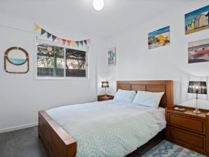 a bedroom with a bed and two windows at Esplanade Escape in Indented Head
