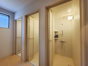 a bathroom with a walk in shower next to a door at モンゴリアンテーマパークジャパン in Kamigō +71 photos