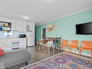 a living room with a kitchen and a table and chairs at Esplanade Escape in Indented Head