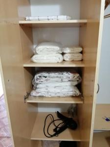 a closet with some white folded towels in it at Мерей 1 in Qyzylorda