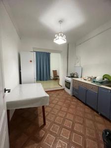 a kitchen with a refrigerator and a table in it at Мерей 1 in Qyzylorda