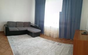 a living room with a couch and a large window at Мерей 1 in Qyzylorda
