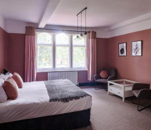 a bedroom with a bed and a window and a chair at 5 bed central home- beautiful modern in Witney +39 photos