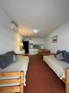 two beds in a room with a kitchen and a table at PontesMar Apartamentos Central in Quarteira