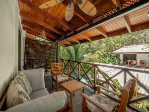 a porch with a couch and chairs on a balcony at Beach Heaven in Playa Guiones