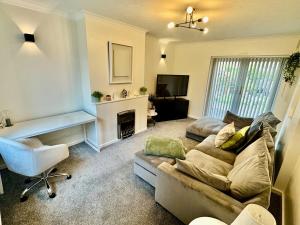 a living room with a couch and a chair at Comfortable 3BR house-parking close to city centre in Kidlington