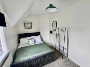 a small bedroom with a bed and a mirror at Comfortable 3BR house-parking close to city centre in Kidlington