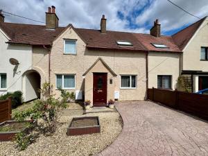a house with a driveway and a brown door at Comfortable 3BR house-parking close to city centre in Kidlington