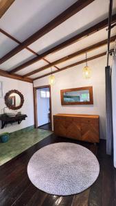 a living room with a rug and a mirror at La Bima Beach House in Sekongkang Bawa